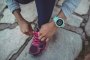 Часы Suunto Spartan Trainer Wrist HR зеленые, фото на руке молодого человека, завязывающего шнурки №7